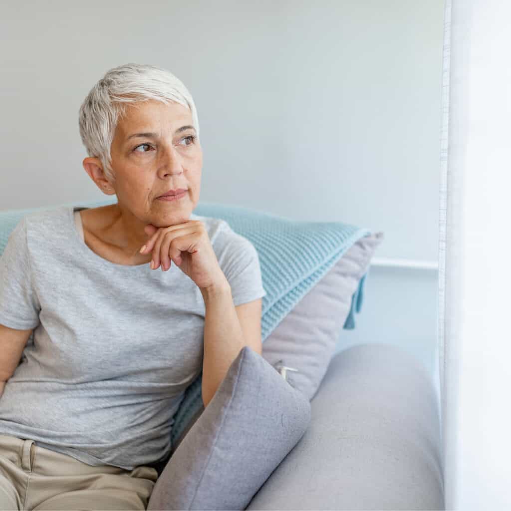 Alterpsychiatrie Kombination ineinanderlaufendes Foto Frau in Gedanken sitzt auf einem Sofa